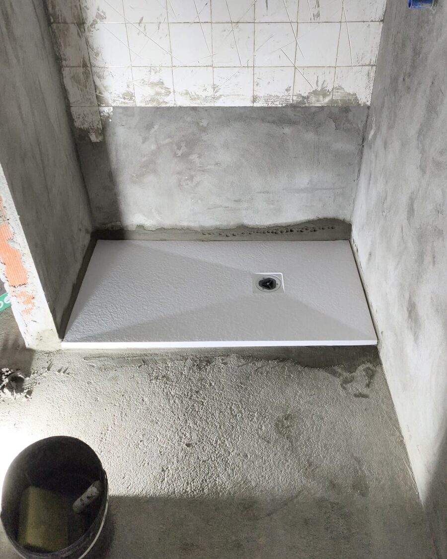 Base de duche nova instalada, obra ainda em acabamento nas paredes