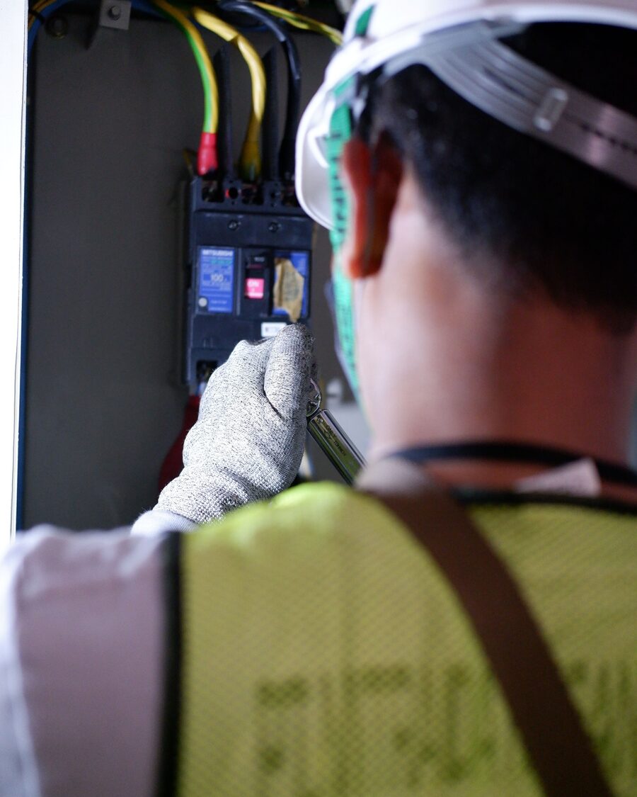 Eletricista a verificar disjuntores no quadro