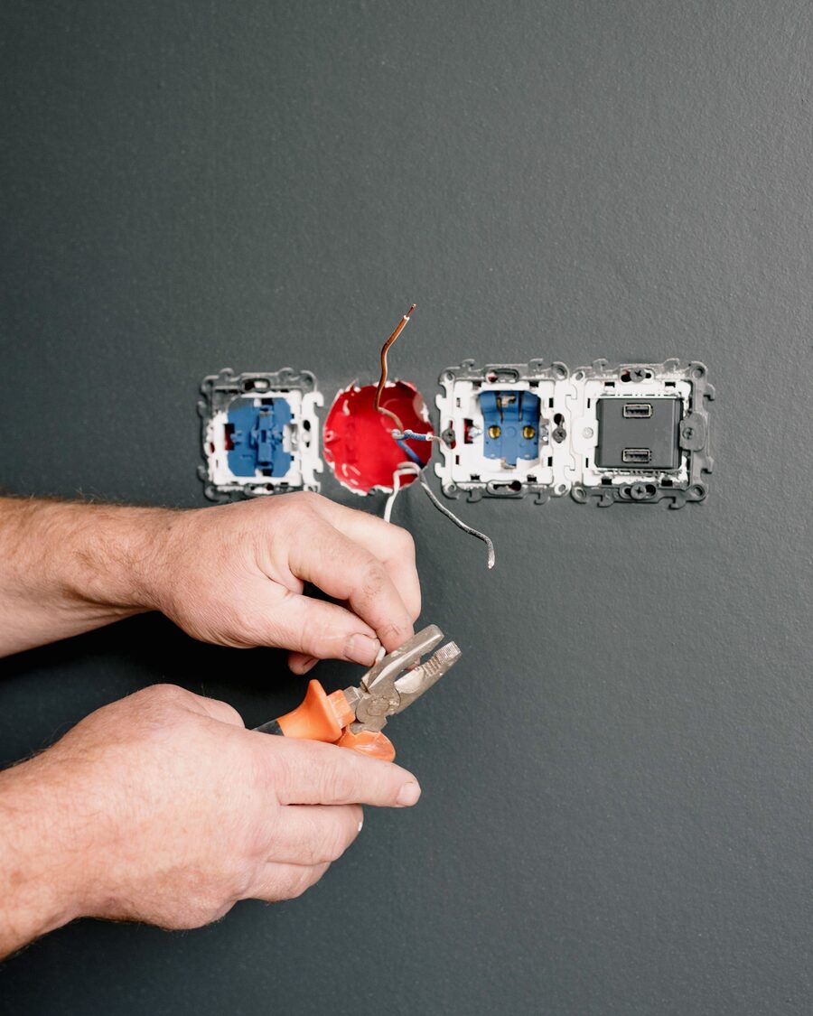Eletricista a reparar tomadas e interruptores na parede
