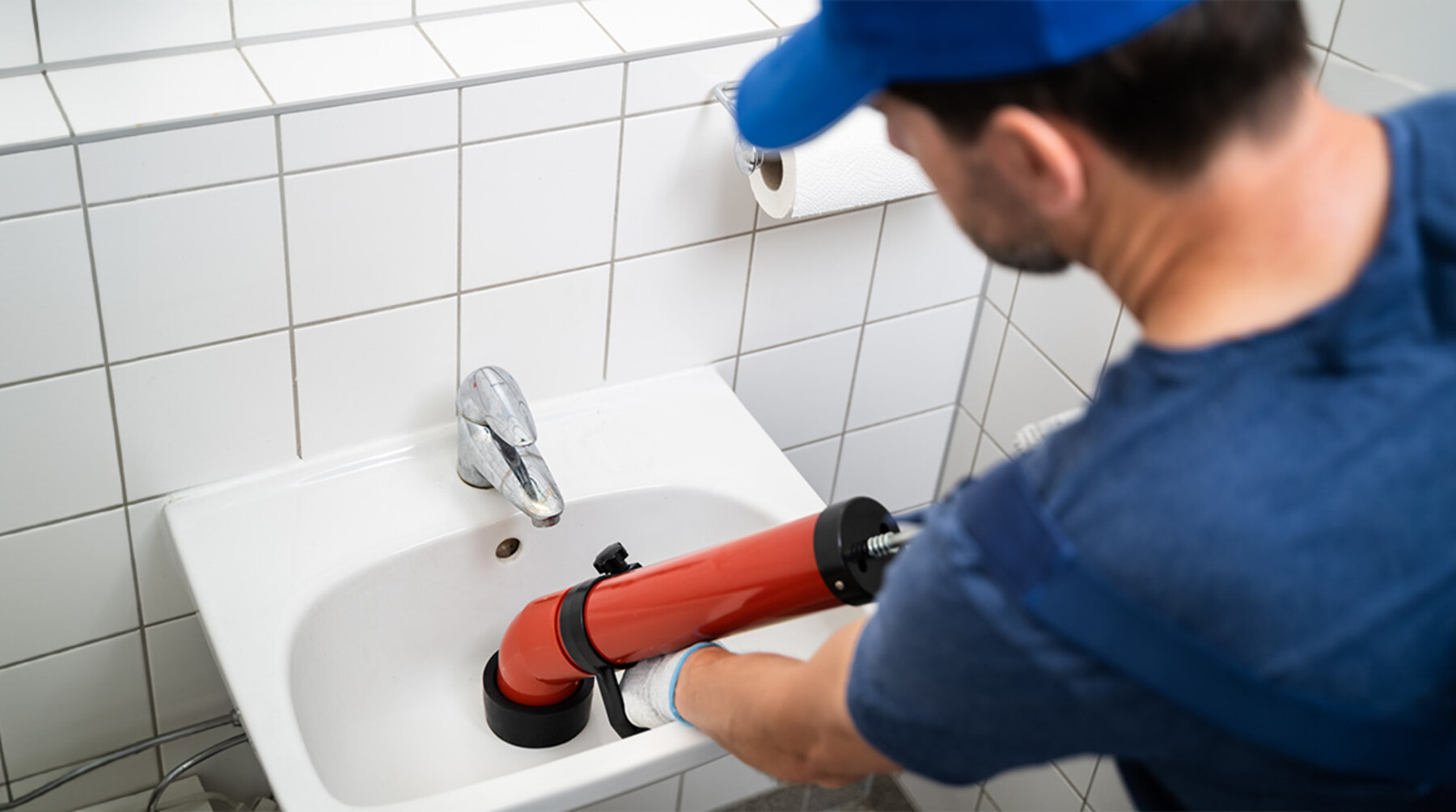 Técnico a desentupir lavatório com máquina de desentupimento profissional